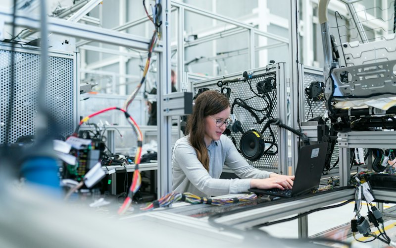 Estudante trabalhando em um laboratório técnico com computador.